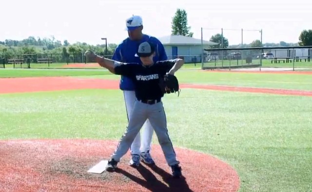 Coach positioning elbow for pitching